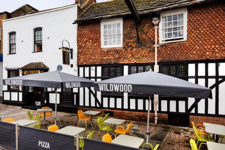 Wildwood, Crawley - exterior showing seating area with branded umbrellas