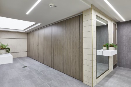 Princesshay Shopping Centre public toilets, Exeter - beige tiling on walls, large floor length mirror with shelf and plants, grey floor tiling, wooden stalls
