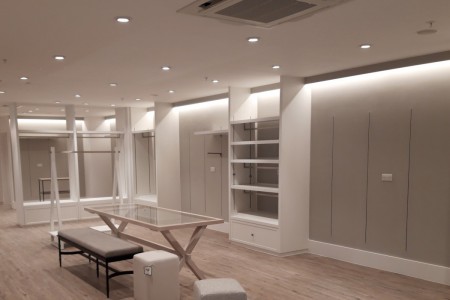 The White Company, Windsor - white walls, downlighting on shelves, wooden floor
