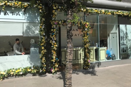 Santa Nata, London - exterior, glass shopfront surrounded by yellow flowers