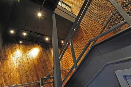 Shake Shack, New Oxford Street, London - wooden cladding on walls, looking up metal staircase