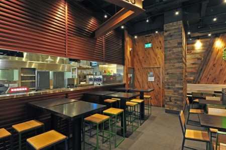 Shake Shack, New Oxford Street, London - wooden clad walls with exposed brick work, neon burger signs, kitchen area, stools and tables