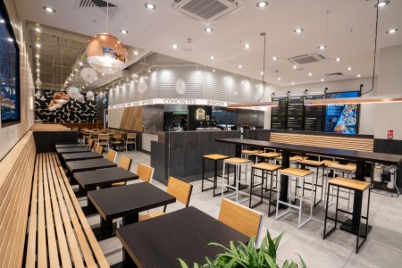 Shake Shack, Brent Cross Shopping Centre, London - interior with wooden bench seating, wooden stools, tables