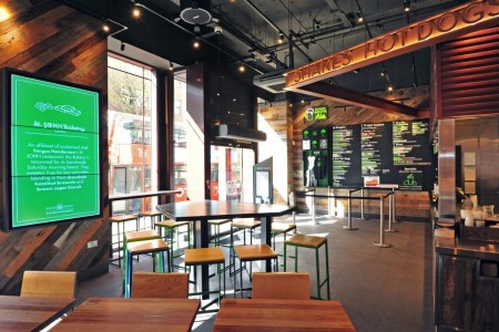 Shake Shack, New Oxford Street, London - exterior, brown branding with white and green logo