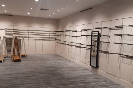 Joules, Cannock - grey wooden flooring, beige walls with empty shelving